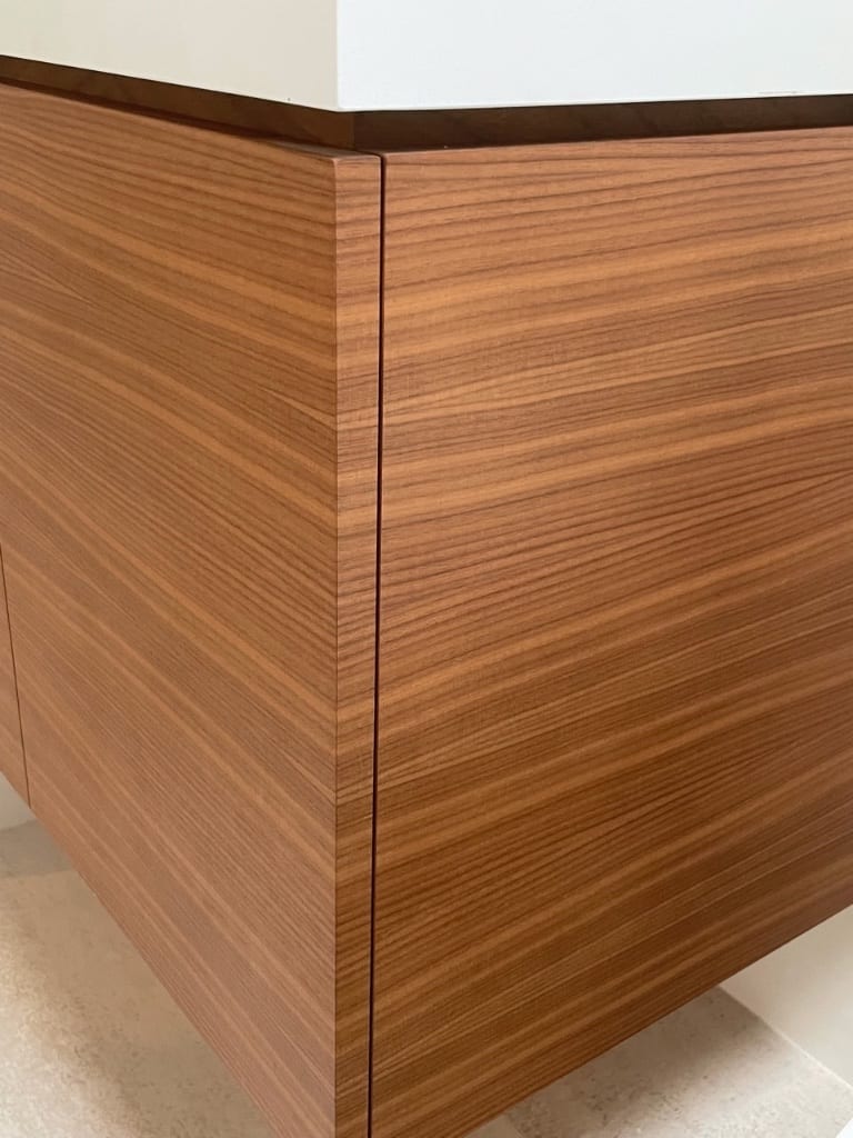 A quartered walnut veneer desk with a sequence-matched top, the grain running unbroken across the whole surface