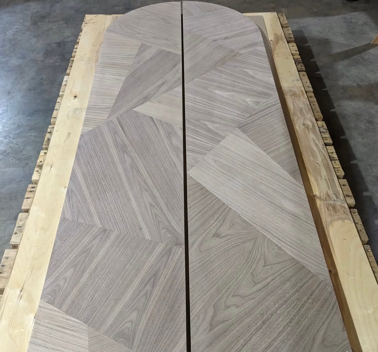 The same arched double doors seen down their length on the bench, the radial layup running the full height of both leaves