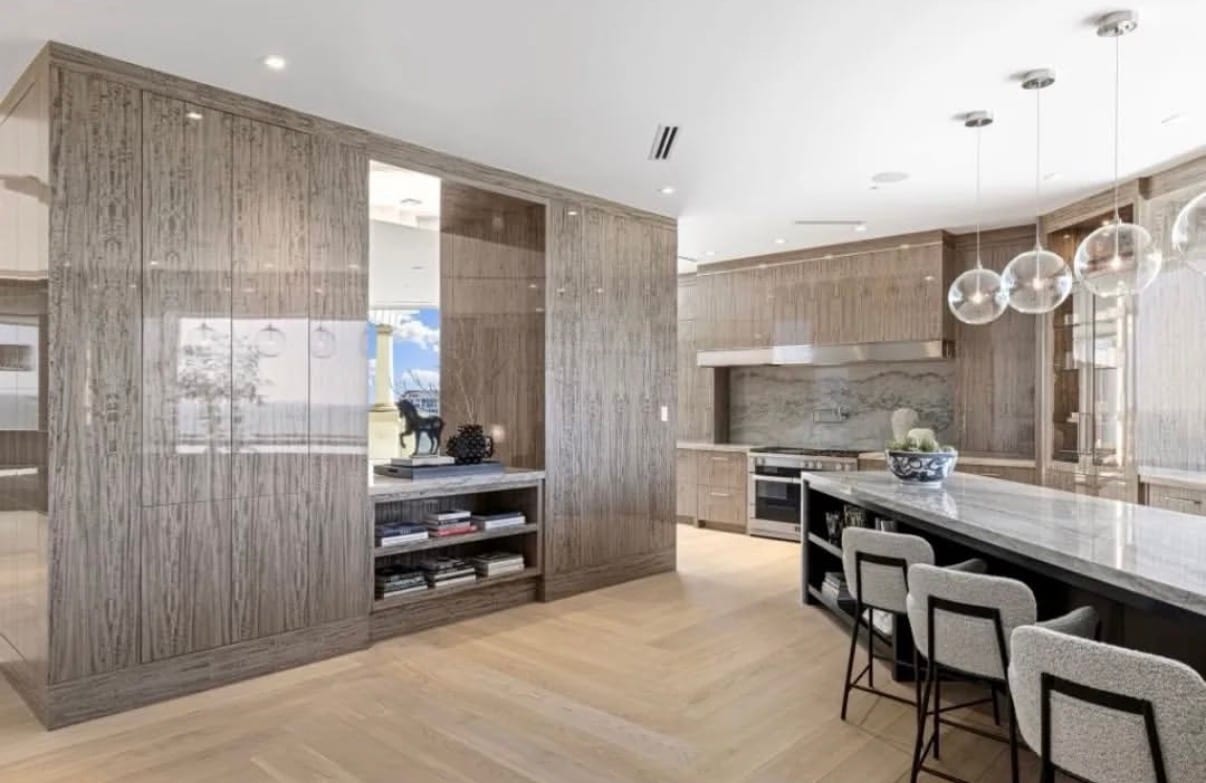 A contemporary kitchen in figured gray dyed eucalyptus veneer, the figure reading as light and shadow rather than color