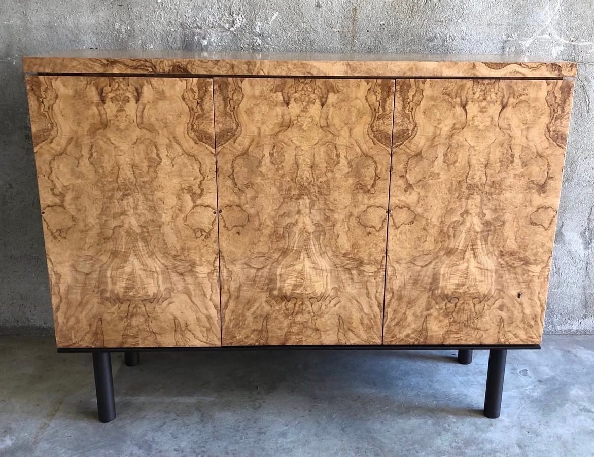 A credenza faced in olive ash burl veneer, swirling burl eyes over a golden ground