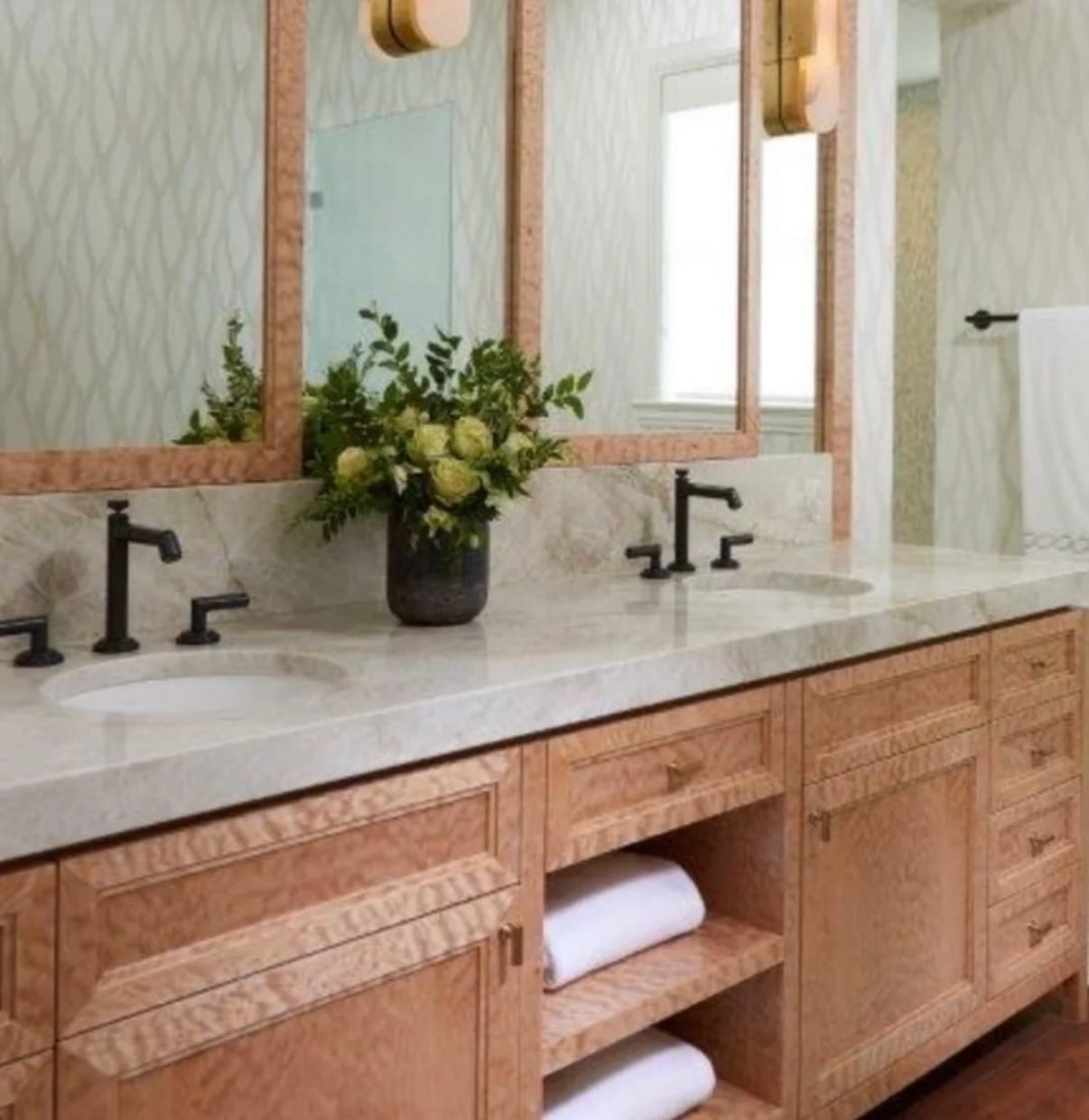 A vanity in quilted maple veneer, the billowing quilt figure catching the light across the drawer fronts