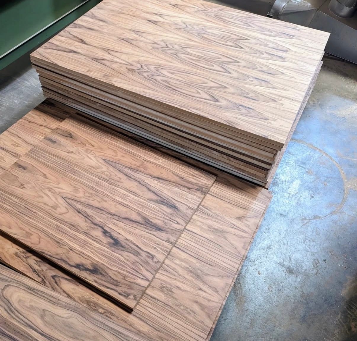 Finished architectural plywood panels faced in santos rosewood veneer, pressed and stacked on the shop floor