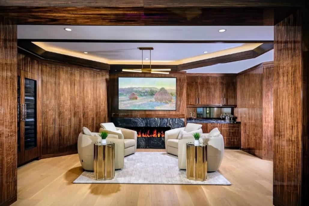 A media room panelled floor to ceiling in French walnut architectural plywood, with a fireplace, integrated joinery and a coffered ceiling